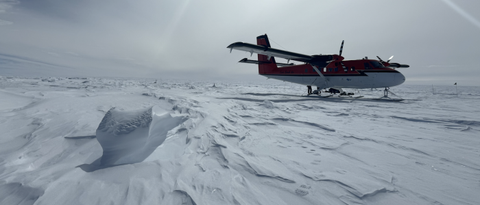 Windblown surface snow and Twin Otter aircraft, interior ice sheet site, East Antarctica.